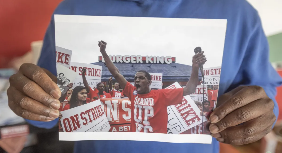 Terrence Wise shows a photograph of his first strike at the Burger King restaurant at 1102 East 47th Street, in 2013, in Kansas City. He was protesting in favor of increasing the minimum wage for low-wage workers. Credit: Jeff Tuttle