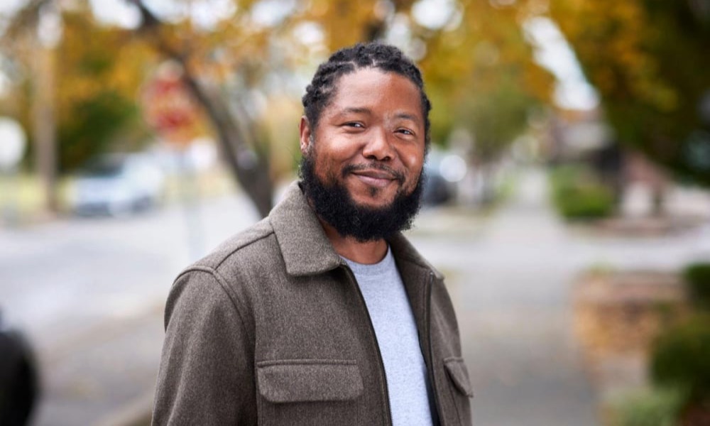 New MFH iconic photo of smiling Black man standing outdoors with autumn trees behind him