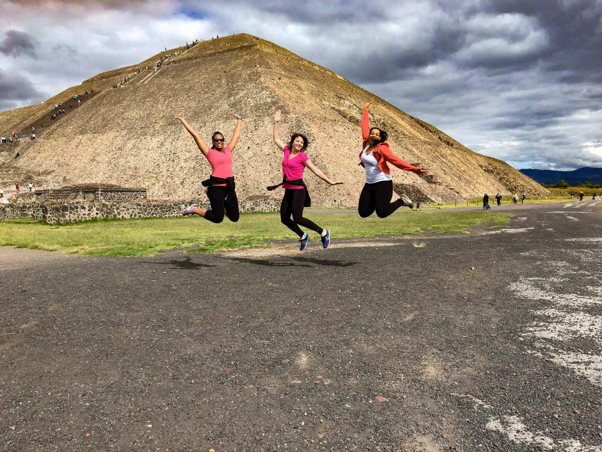 Photo of Ivory and friends posing in mid-air in front of pyramids in Mexico City