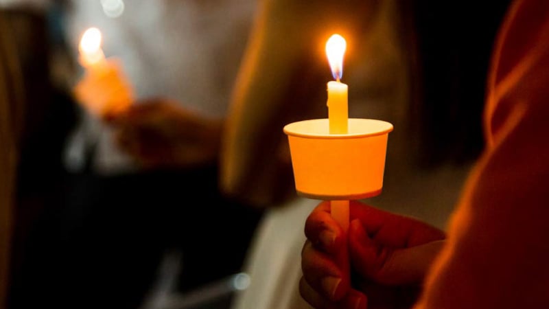 Person holding candle during vigil