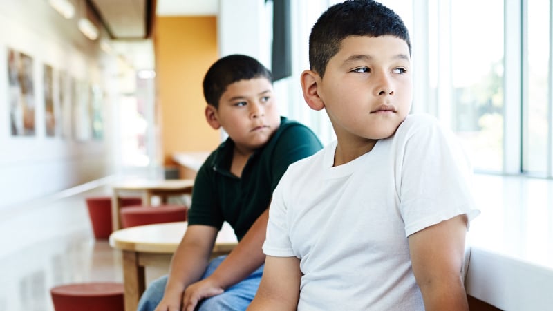 2 young Hispanic boys in waiting room at medical center