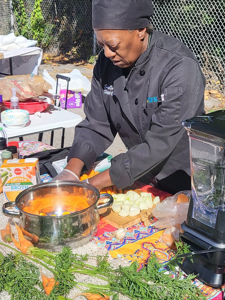 Healthy Community Market chef preparing fresh produce in a demonstration outdoors