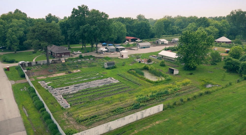 Rustic roots farm aerial image of the community farm's produce, structures, and fence