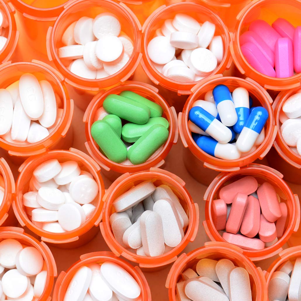 overhead photo of various pills in prescription bottles