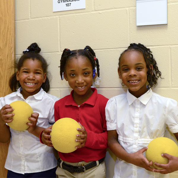 Image of three girls holding playground balls