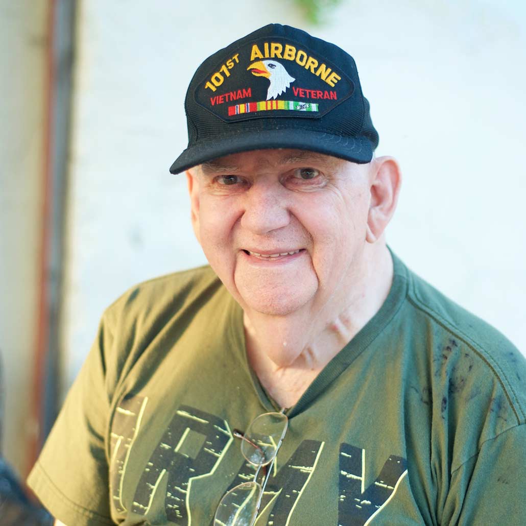 Senior white male Veteran sitting outside smiling