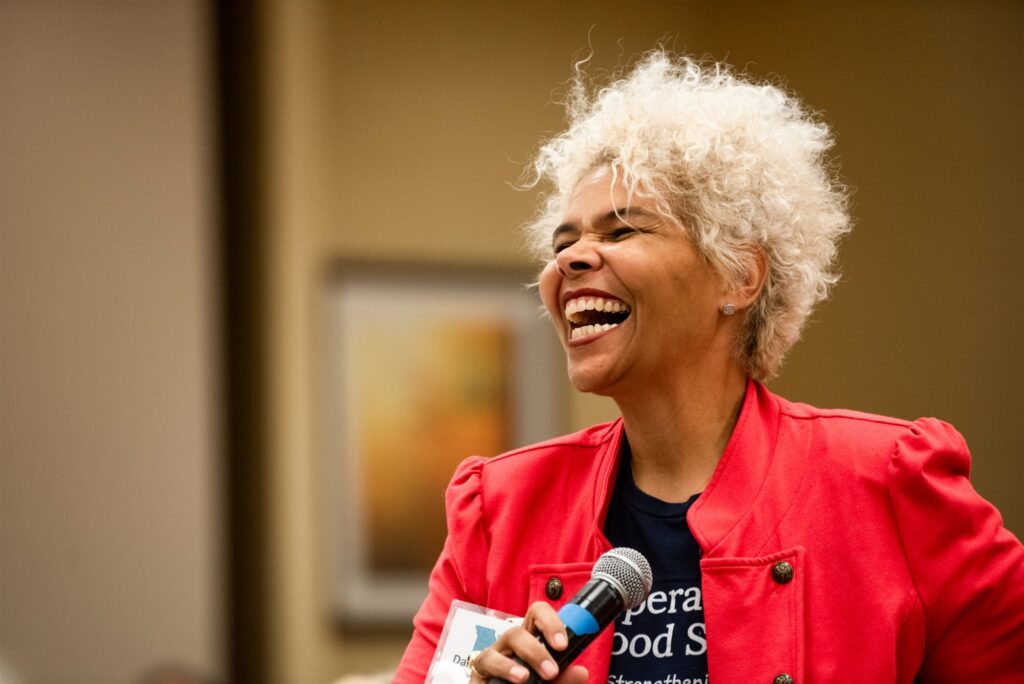A participant laughs while holdinga microphone at the Advocates’ Retreat