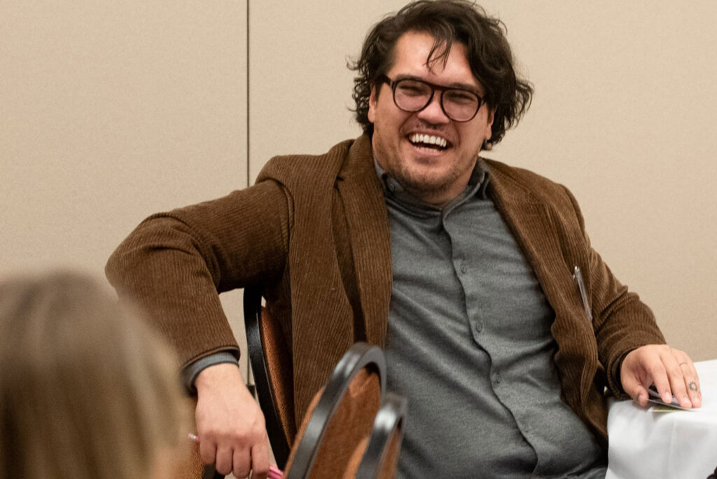 A participant smiles at person in foreground at the Advocates’ Retreat